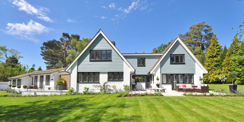 two-story white and gray suburbian home on clear day with freshly cut lawn