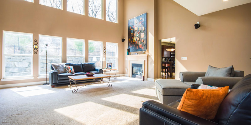 living room with vaulted ceiling, sunlight shining through windows, and sofa furniture