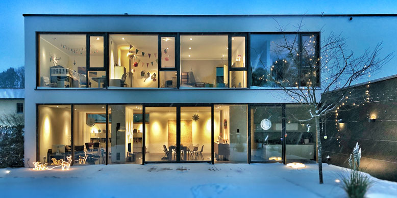 two-story home with flat roof in evening during wintertime