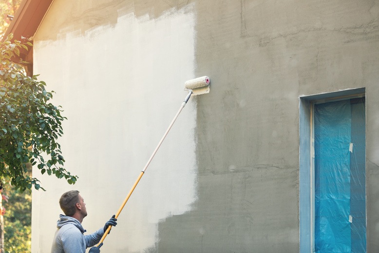 man painting exterior of house in missouri