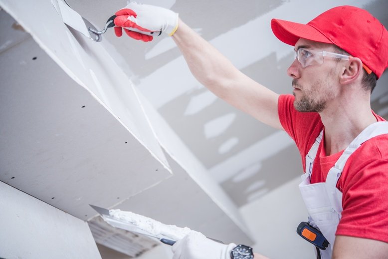 professional painter spackling interior walls before painting