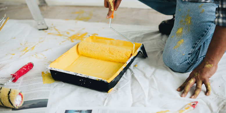 rolling yellow paint in paint tray
