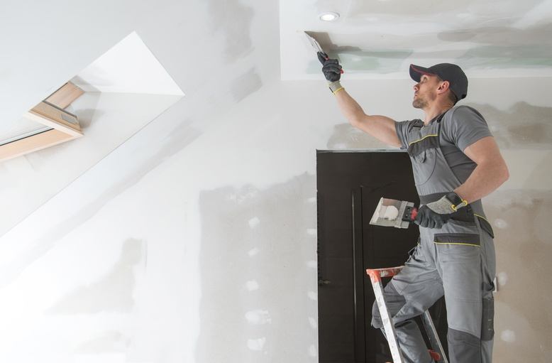 professional painter repairing damaged drywall