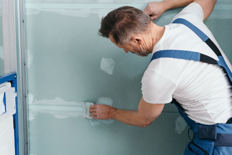 professional painter repairing damaged drywall