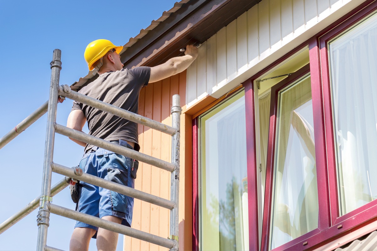 painter painting home exterior from the top down