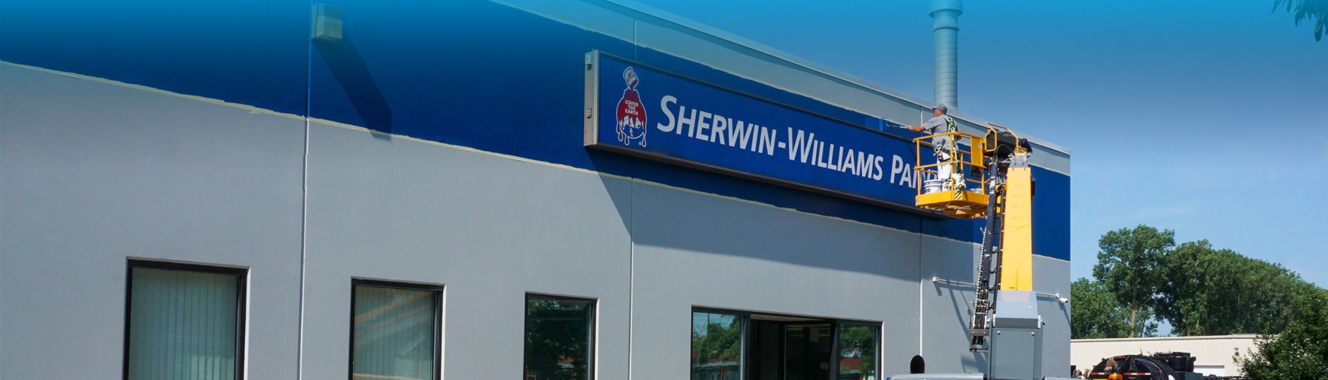 painter painting the exterior of a Sherwin Williams store